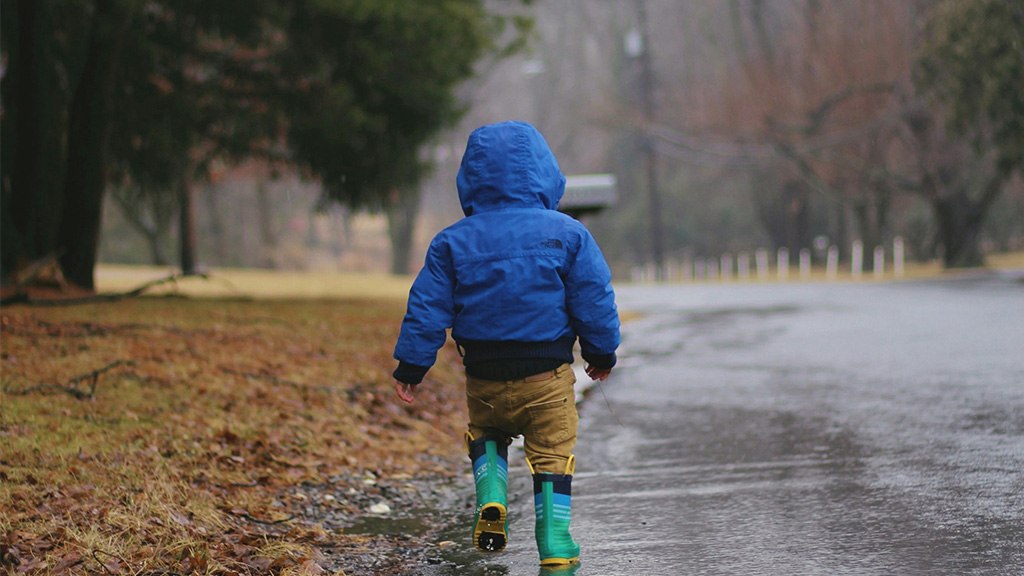 Photo: Toddler walking on road while raining; Source: Photo by June Admiraal on Unsplash, https://unsplash.com/photos/toddler-walking-on-road-while-raining-2JEcozuh9mU