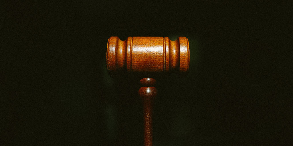 photo of a wooden gavel in a black background, Credit: Photo by Tingey Injury Law Firm on Unsplash, https://unsplash.com/photos/nSpj-Z12lX0