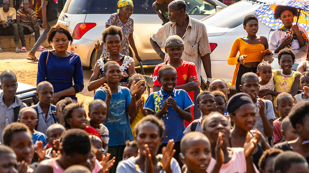 A group of people standing in front of a crowd. Photo by Sikwe Scarter on Unsplash, https://unsplash.com/photos/a-group-of-people-standing-in-front-of-a-crowd-9o4PMXKp2dk